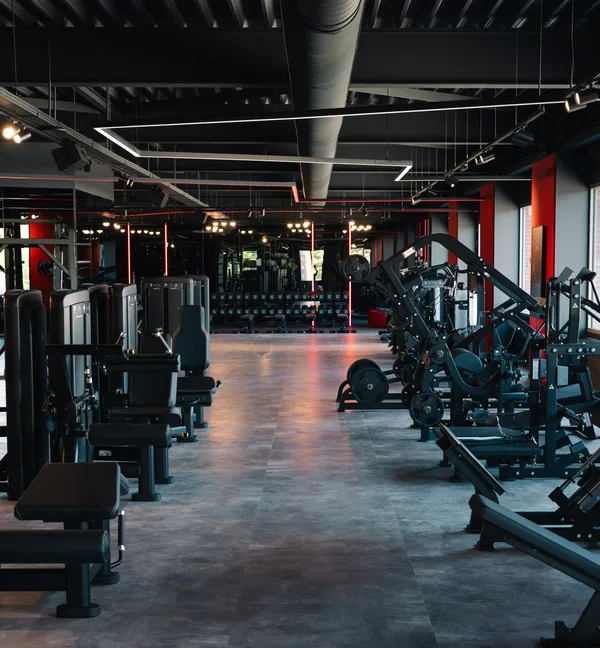 Rijen krachtmachines en leg presses in de krachtzaal van XXL Gym Helmond