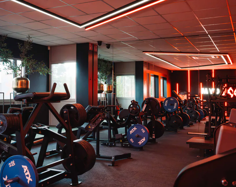 Plate-loaded krachtmachines met ATX-schijven onder rode verlichting in XXL Gym Nuenen