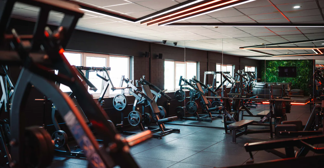 De krachtzaal van XXL Gym Nuenen met plate-loaded machines en daglicht